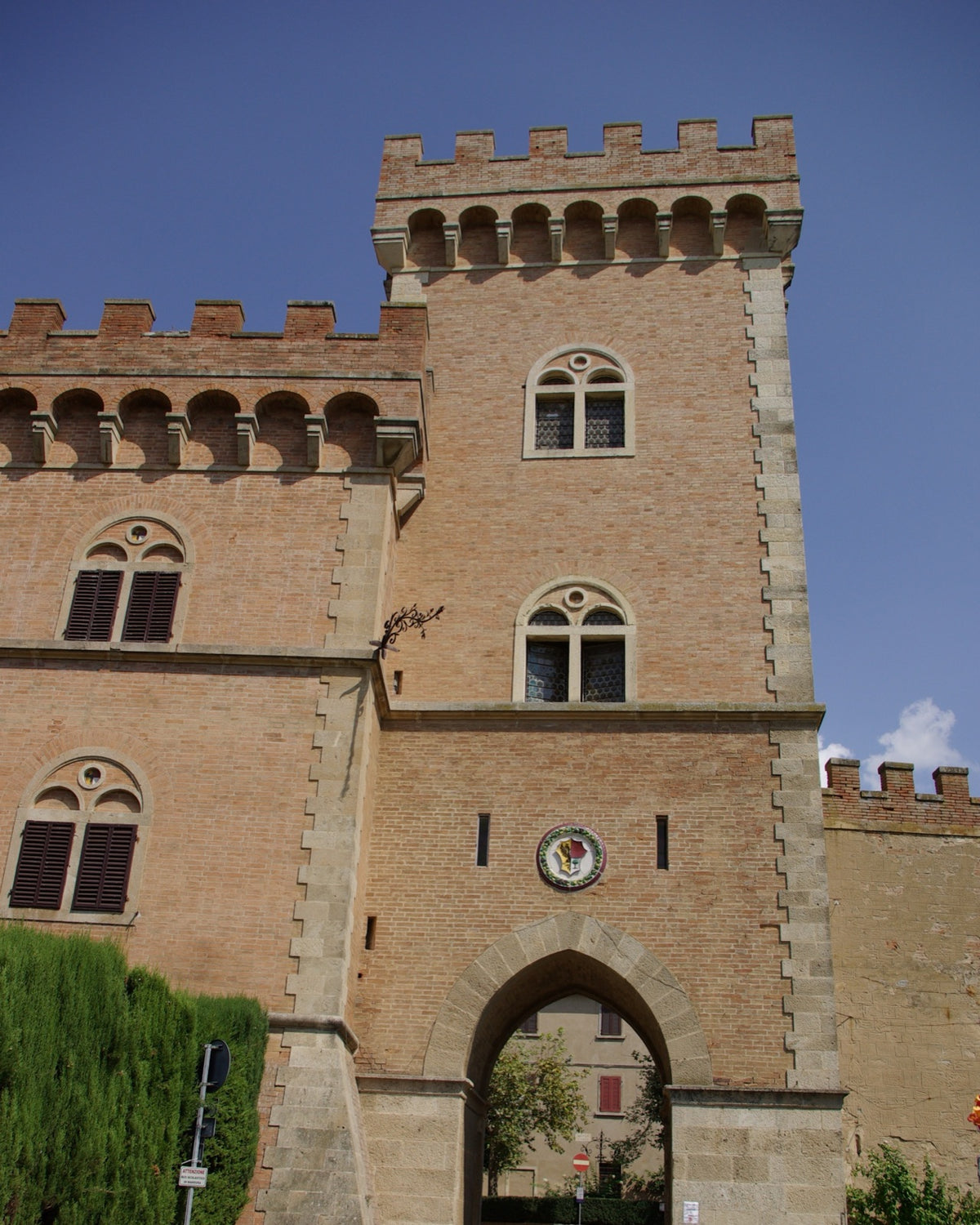 La porta-torre merlata del castello di Bolgheri, con lo stemma e l’arco d’ingresso al borgo